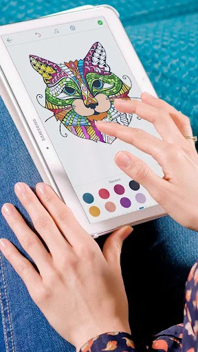 Adult coloring app with mandala cat design partially painted on tablet using brush tool and colorful palette selector