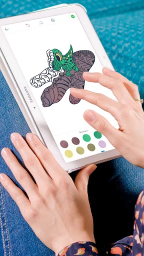 Adult dinosaur coloring book in action: hands on tablet painting dino with touch interface and colors
