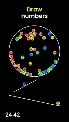 Lottery number picker showing draw in progress with colorful balls scattered in chamber, numbers 24 42 displayed at bottom